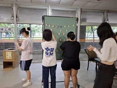 同學將木片貼在活動公佈欄上圖片